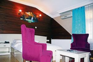特拉布宗Bordo Hotel的卧室配有粉红色的椅子和一张床