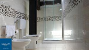 马尔扎梅米Le Saline Rooms Marzamemi的一间带卫生间和玻璃淋浴间的浴室