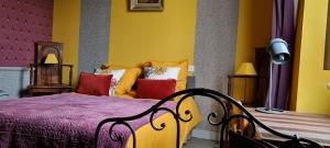 CordemaisGîte Mido的黄色卧室配有红色枕头的床