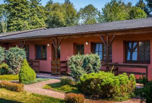 日恰尼奥扎察尼酒店的一座粉红色的房子,里面种有灌木和树木