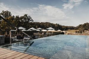 DalaröSmådalarö Gård Hotell & Spa的木制甲板上带遮阳伞的游泳池