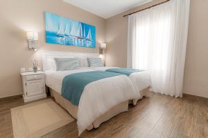 科斯塔特吉塞维托克拉斯兰萨罗特度假公寓的一间卧室配有一张带蓝白色床单的大床