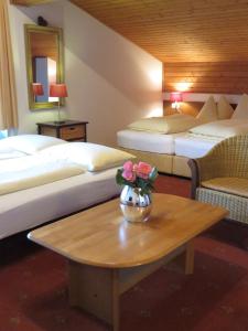 皮森多夫塞耶运动膳食公寓酒店的酒店客房,设有两张床和一张带鲜花的桌子。