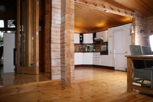 TaalintehdasVilla Bergholmen的开放式厨房设有木墙和木地板