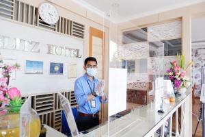 巴淡岛中心Blitz Hotel Batam Centre的一个戴面具的人站在房间里