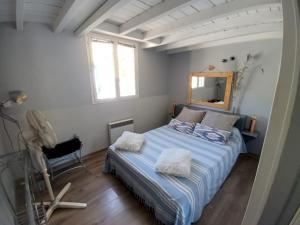 西让Maison de pecheur的一间卧室配有一张带镜子和椅子的床