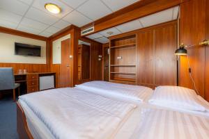 布达佩斯格兰德朱尔斯 - 船屋的一间卧室配有一张带木墙的大床和一张书桌