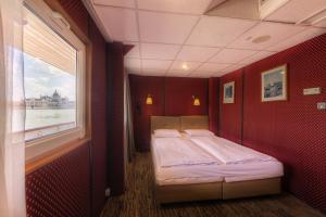 布达佩斯格兰德朱尔斯 - 船屋的一间设有床铺的卧室,位于带窗户的红色房间