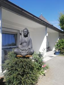 达姆施塔特茵恩斯塔德特纳赫公寓民宿的坐在房子边的佛陀雕像