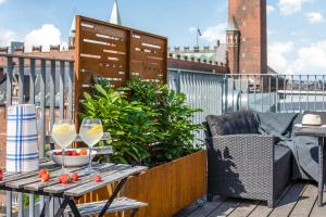 哥本哈根City Square Hotel Apartments的阳台配有带一碗水果和酒杯的桌子。