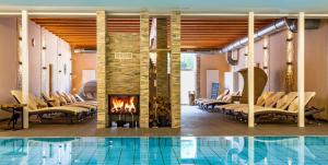 巴特萨尔奇利夫巴德霍夫酒店的酒店大堂设有游泳池、椅子和壁炉