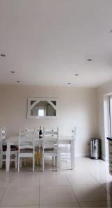 康多纳Modern Home Carndonagh的白色的用餐室配有白色的桌椅