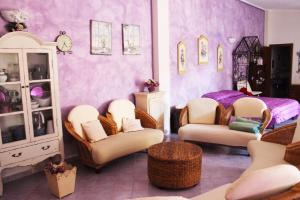 奥罗塞伊Villa Marina的一间带椅子的房间和一间带紫色墙壁的卧室