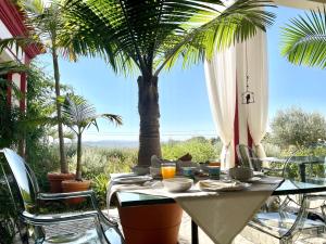 托马尔Best Luxury Boutique B&B Vista do Vale Tomar的天井上配有桌椅和棕榈树
