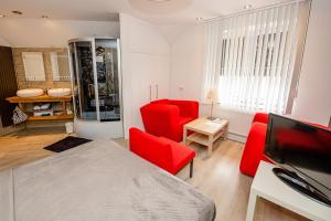 MerkelbeekB & B M 3的客厅配有红色椅子和电视