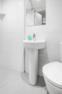 伦敦肯辛顿阿斯特旅舍的白色的浴室设有水槽和卫生间。