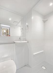 伦敦肯辛顿阿斯特旅舍的白色的浴室设有水槽和卫生间。