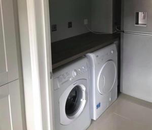 赫彻姆Inviting 2-Bed Bungalow in Heacham with spa bath的厨房里配有洗衣机和烘干机,旁边是冰箱