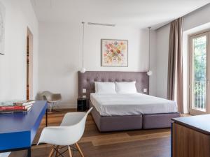 佛罗伦萨numa I Vita Apartments的一间卧室配有一张带蓝色书桌和一张桌子的床。