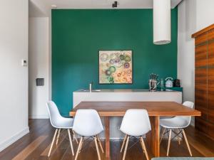 佛罗伦萨numa I Vita Apartments的一间设有绿色墙壁、木桌和白色椅子的用餐室