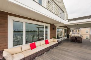 大西洋城Lago-mar Luxury Modern Waterfront Home的门廊上的沙发,配有红色枕头
