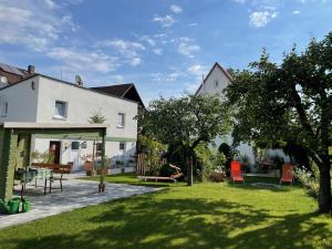 StrullendorfFerien-Apartment Beller的房屋,设有庭院,配有椅子和树木