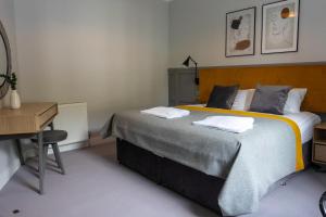 奥本Airds Apartments的一间卧室配有一张大床和一张书桌