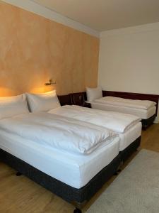 圣加仑Boutique City Hotel Gallo的配有白色床单的酒店客房内的两张床