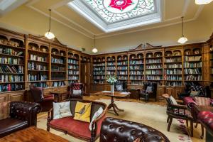阿尼克多克斯福德Spa酒店 的图书馆设有皮椅、书架和窗户