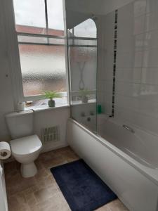 斯卡伯勒Sandyrise holiday lets的带浴缸、卫生间和窗户的浴室
