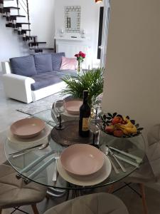 耶莱尼亚古拉Apartament Kwiat Lotosu的一张带盘子的玻璃桌和一瓶葡萄酒