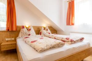 艾奇Pernerhof的卧室内的两张床,配有橙色窗帘