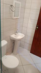 陶巴特Acomodações Silvestre的白色的浴室设有卫生间和水槽。
