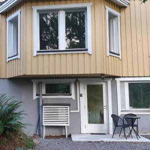 基尔科努米Sydåbacka Guest House, a Room with a Sauna的房屋前设有两把椅子和一张桌子