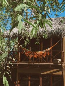 巴拉格兰德Pousada Rota dos Ventos的树屋,茅草屋顶和吊床