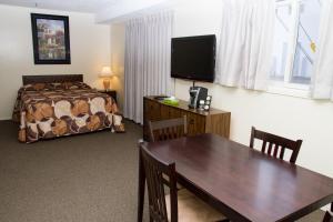 Assiniboia车轮汽车旅馆的酒店客房设有餐桌和床。