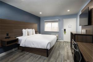 阿罗约格兰德Days Inn by Wyndham Arroyo Grande Pismo Beach的酒店客房,配有床和电视