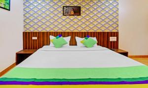 马迪凯里Treebo Trend Igloo Residency Raja Seat的卧室配有一张带彩色枕头的大型白色床。