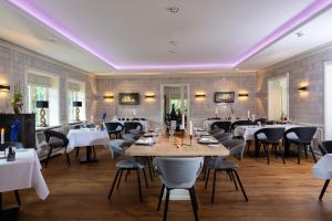 凯图姆Benen-Diken-Hof的一间配备有桌椅和紫色照明的用餐室