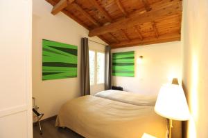 Saint-Romain-de-LerpsVilla Rouvesol的墙上挂有绿色绘画的客房内的两张床