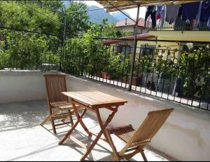 博梅拉诺Casa Torre的阳台上配有一张木桌和两把椅子