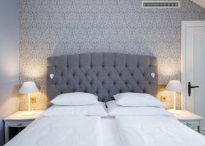 维尔扬迪Schloss Fellin Boutique Hotel and Spa的一间卧室配有一张带两盏灯的大型白色床。