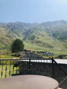 卡兹贝吉Wander Kazbegi Hotel的山景阳台(带桌子)