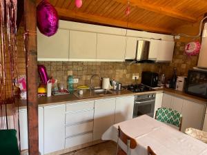 曼加利亚Vila H2O的厨房配有白色橱柜、水槽和桌子