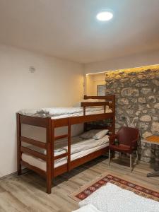 VusanjeRiverside Guesthouse的石墙客房设有一间带双层床的卧室