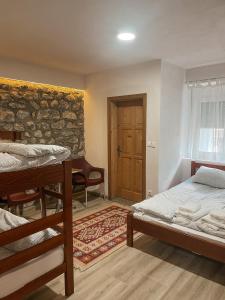 VusanjeRiverside Guesthouse的一间卧室设有两张床和砖墙