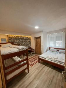 VusanjeRiverside Guesthouse的一间卧室设有两张双层床和砖墙