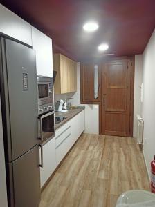 圣埃斯特万德戈尔马斯Casa Rural El Mirador de San Miguel的厨房配有不锈钢冰箱和木制橱柜