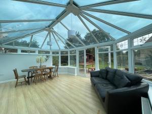 温什科姆3 Bed Bungalow in Winchcombe, Cotswolds,Gloucester的一个带沙发和桌椅的温室