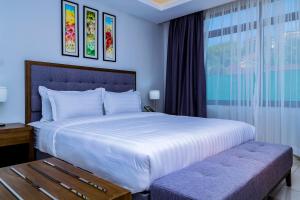 坎帕拉Canary Hotel Kampala的卧室设有一张白色大床和一扇窗户。